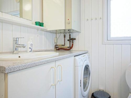 een witte keuken met een wastafel en een wasmachine bij Holiday home Aakirkeby XIV in Vester Sømarken