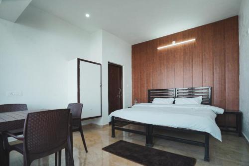- une chambre avec un grand lit et un mur en bois dans l'établissement Spandan Villas, à Dhanaulti