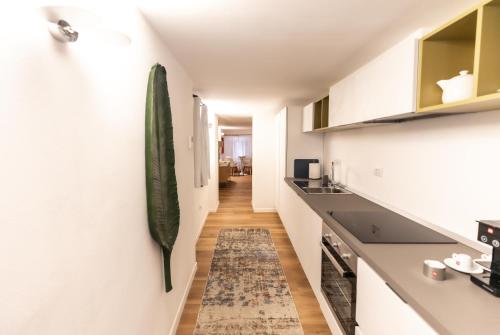 a kitchen with white cabinets and a rug on the floor at Grand Hotel Duchi d'Aosta Apartments in Trieste