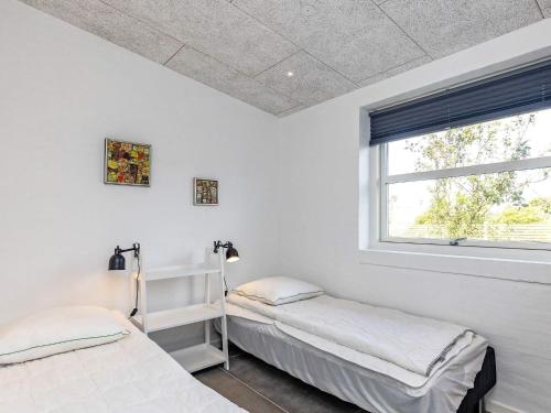 two beds in a white room with a window at Holiday home Vestervig XXXIV in Vestervig