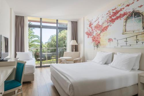 1 dormitorio con cama blanca y ventana grande en Iberostar Bellevue All Inclusive, en Budva