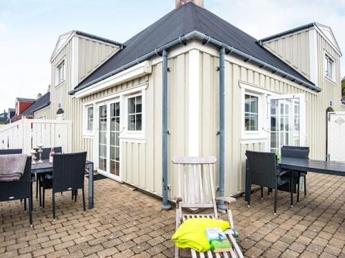 un gran edificio blanco con mesa y sillas en 4 person holiday home in Ringk bing, en Ringkøbing