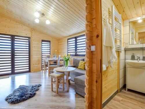 a log cabin with a kitchen and a dining room at Domki na Wzgórzu in Kudowa-Zdrój