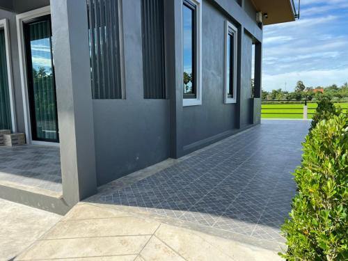 a house with a tile walkway in front of a door at ลานนา รีสอร์ท in Ban Thap Khang