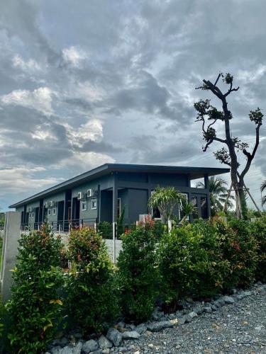 a blue building with a tree in front of it at ลานนา รีสอร์ท in Ban Thap Khang