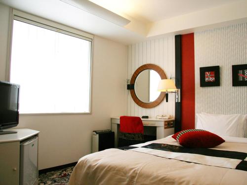 um quarto de hotel com uma cama e uma televisão em New Otani Inn Tokyo em Tóquio