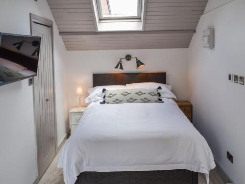 1 dormitorio con cama blanca y ventana en The Turret, en Easingwold