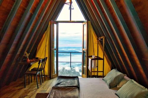 a room with a bed and a large window at The Backyard Balangoda in Balangoda