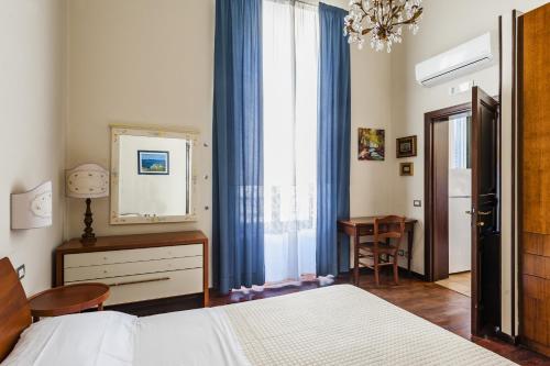 sypialnia z łóżkiem, biurkiem i lustrem w obiekcie Grimaldi 8 Apartment by Wonderful Italy w Katanii