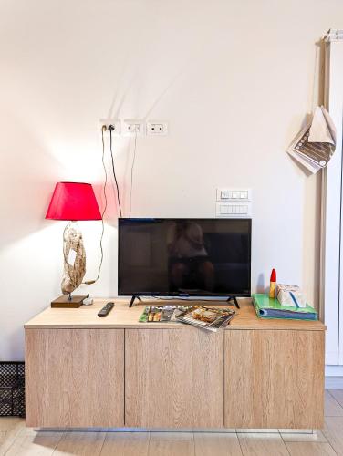 a living room with a television and a table with a lamp at Agriturismo Ardizio 43 in Pesaro