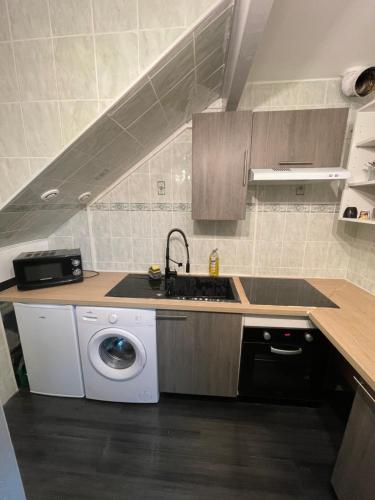 a kitchen with a sink and a washing machine at Charmant logement proche Disneyland Paris parking in Lagny
