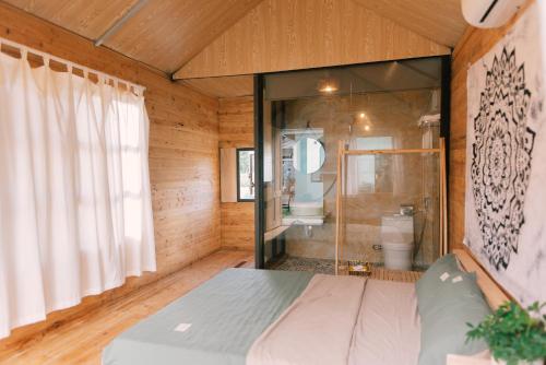 a bedroom with a shower and a bed in a room at Lacasa home&coffee Mộc Châu in Mộc Châu