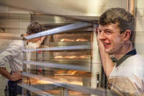 two men in a kitchen preparing food in a bakery at Sonnenhotel Adler Spa & Nature Adults only in Villandro