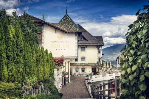 a building with a sign on the side of it at Sonnenhotel Adler Spa & Nature Adults only in Villandro