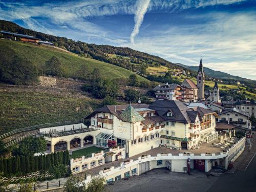 an aerial view of a large building with a church at Sonnenhotel Adler Spa & Nature Adults only in Villandro