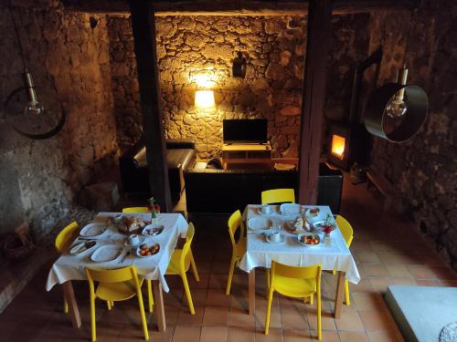 a dining room with two tables and yellow chairs at Zocailla in Gata