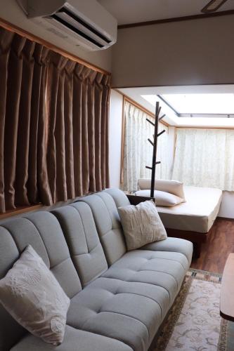 ein Wohnzimmer mit einer Couch und einem Fenster in der Unterkunft cottage SOUL MATE in Ishigaki-jima