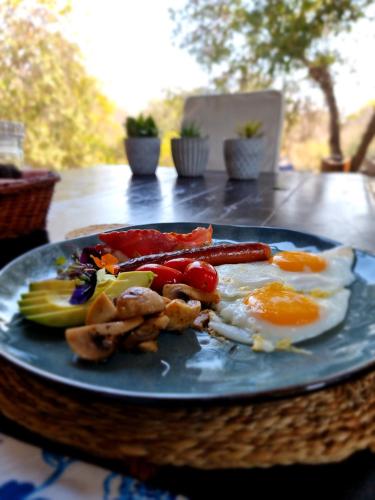 a blue plate with breakfast food on a table at Leopard's Lair Bush Lodge in Hoedspruit