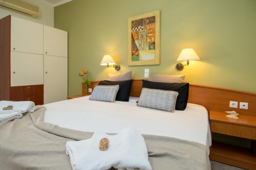 a bedroom with a large white bed with towels on it at Spira Studios & Apartments in the Heart of Laganas in Laganas