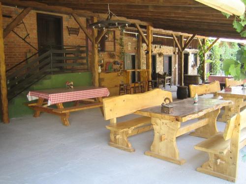 a patio with wooden tables and benches in a building at Apartment at Agroturizam OPG Kovacevic in Daruvar