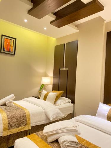 a hotel room with two beds and a ceiling at Raihana for serviced apartment in Jeddah