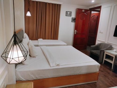 a hotel room with two beds and a lamp at Khách Sạn A83Hotel in Hanoi