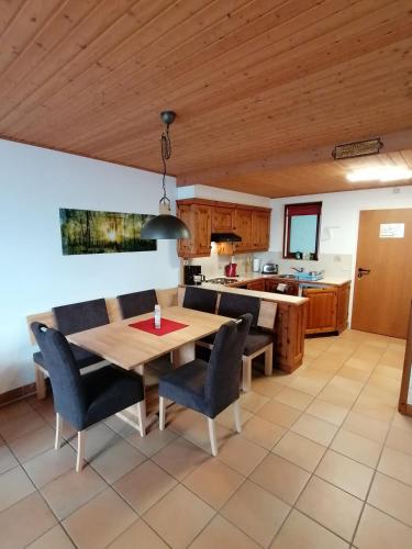 a kitchen and dining room with a wooden table and chairs at Gerlitzen Ferienappartement Paul im Ski- und Wandergebiet, Kanzelhöhe, Ossiacher See in Deutschberg