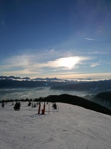 a view of a snowy mountain with the sun in the sky at Gerlitzen Ferienappartement Paul im Ski- und Wandergebiet, Kanzelhöhe, Ossiacher See in Deutschberg