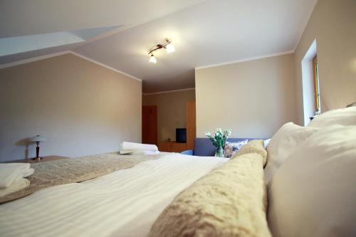 a bedroom with a bed with white sheets and pillows at Penzion Bawaria in Horní Lomná