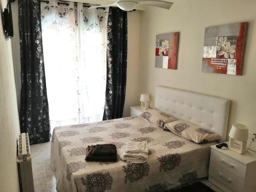 a bedroom with a bed and a large window at Precioso apartamento de lujo in Torredembarra