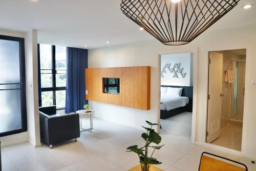 un soggiorno con una camera con un letto e una sedia di 130 Hotel & Residence Bangkok a Bangkok