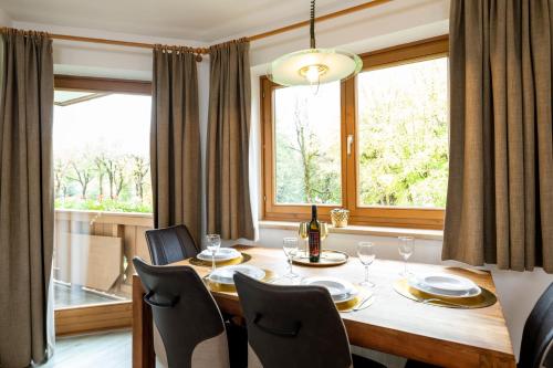 una sala da pranzo con tavolo, sedie e finestra di Appartementhaus Arzt a Zell am See