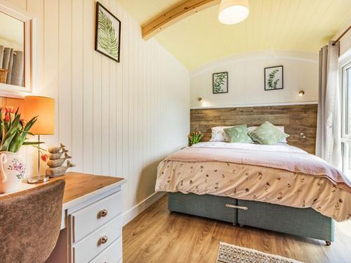 a bedroom with a bed with a wooden headboard at Ponsford Ponds - Goosedown Lodge in Cullompton