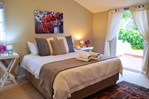 a bedroom with a bed with two towels on it at Bougainvillea House - The Heart of Simonstown in Simonʼs Town