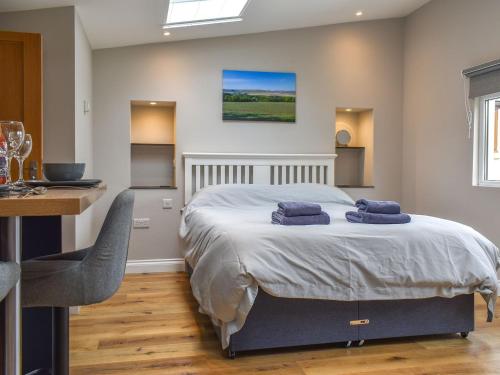 una camera da letto con un letto con due asciugamani blu sopra di Durcombe Water Annexe a Barbrook
