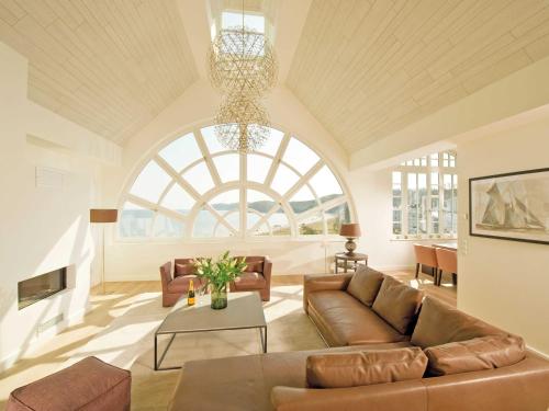 ein Wohnzimmer mit einem Sofa und einem großen Fenster in der Unterkunft Strandschloss Binz - Penthouse "Royal Beach" mit Sauna, Kamin, Terrasse, Meerblick in Binz