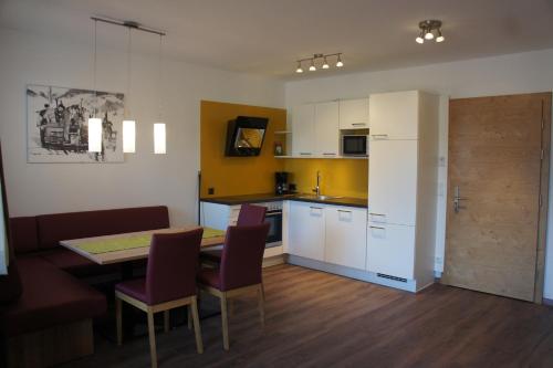 a kitchen and dining room with a table and chairs at Apart Alpin in Lermoos