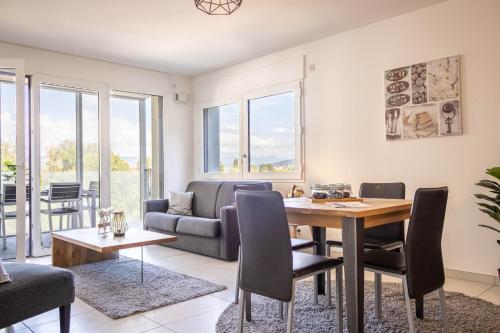 un salon avec une table et un canapé dans l'établissement LE TRESUM - Garage, Balcon & Vue lac!, à Annecy