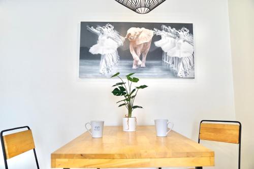 a dining room table with an elephant picture on the wall at 130 Hotel & Residence Bangkok in Bangkok