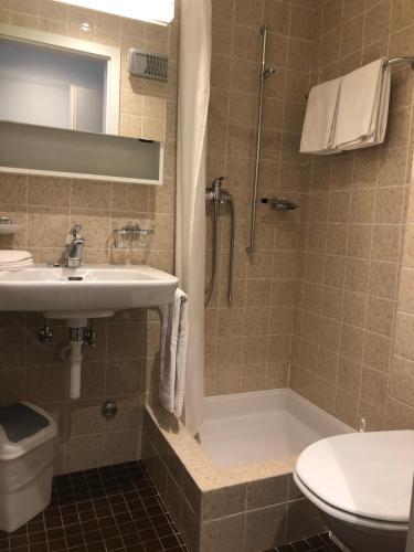 bagno con lavandino, doccia e servizi igienici di Hotel Weisses Kreuz Bergün a Bergün
