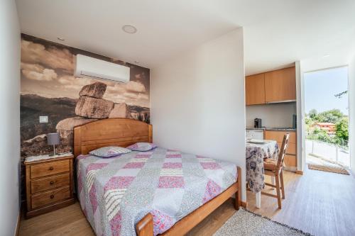 a bedroom with a bed with a painting on the wall at Canastro do Vidoeiro in Vieira do Minho