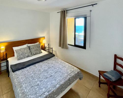 een slaapkamer met een groot bed en een raam bij Vista La Gomera in Puerto de Santiago