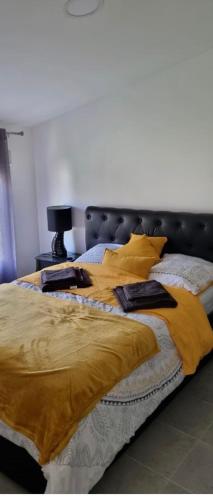 a bedroom with two beds with yellow blankets and pillows at R1/logement proche de Paris - VILLIERS LE BEL (95) in Villiers-le-Bel