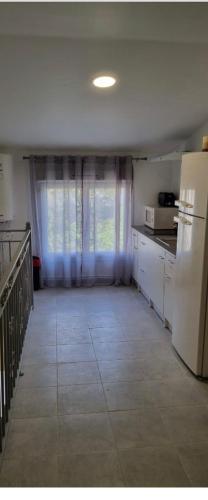 une cuisine avec un réfrigérateur blanc et une fenêtre dans l'établissement R1/logement proche de Paris - VILLIERS LE BEL (95), à Villiers-le-Bel