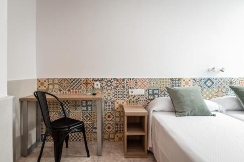 a bedroom with a desk and a bed and a chair at Hostal Baler in Barcelona