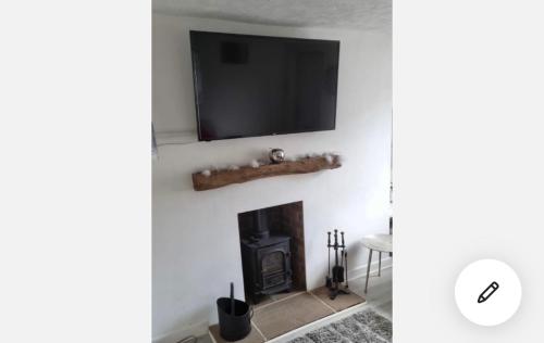 a living room with a fireplace and a flat screen tv at Modern Single room for rental in Colchester Town Centre! in Colchester