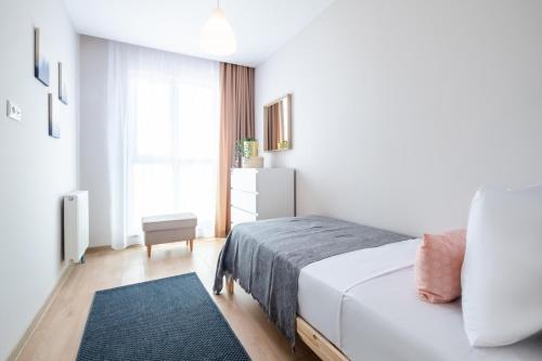 a white bedroom with a bed and a window at Sleek Flat in Kagithane with Terrace in Istanbul