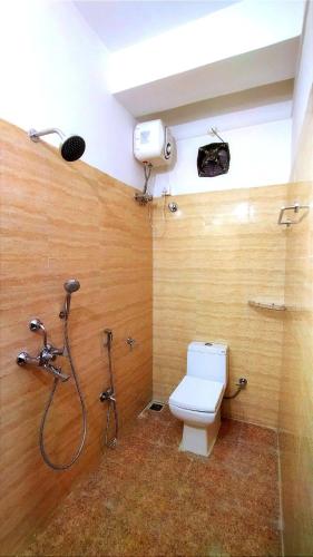 a bathroom with a shower and a toilet in a room at Continental Homestay in Port Blair