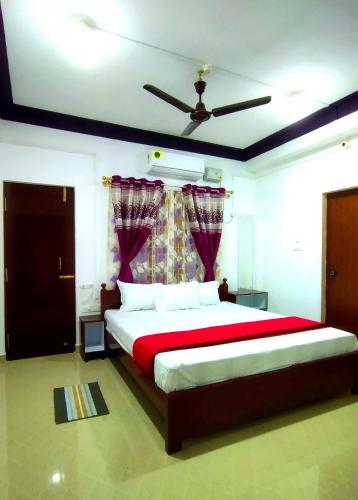 a bedroom with a large bed with a red blanket at Continental Homestay in Port Blair