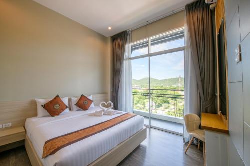 a bedroom with a bed and a large window at UR The Private Huahin in Hua Hin